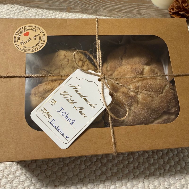 Close-up of a cookie box window showing Vegan Snickerdoodles, with a Handmade With Love gift tag