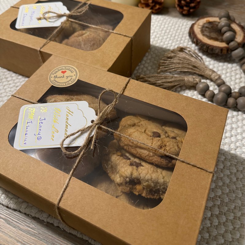 A box of Butterscotch Toffee cookies with a gift tag on a cozy table setting